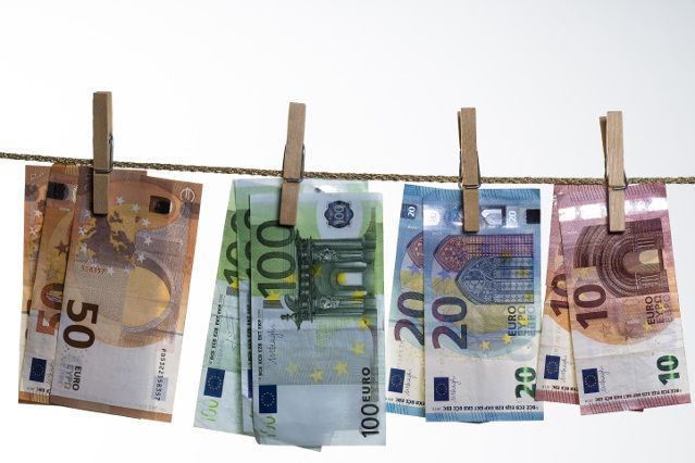 verschiedene Geldscheine sind mit einer Wäscheklammer an einer Leine aufgehängt (verweist auf: Zentralstelle für Finanztransaktionsuntersuchungen - FIU)